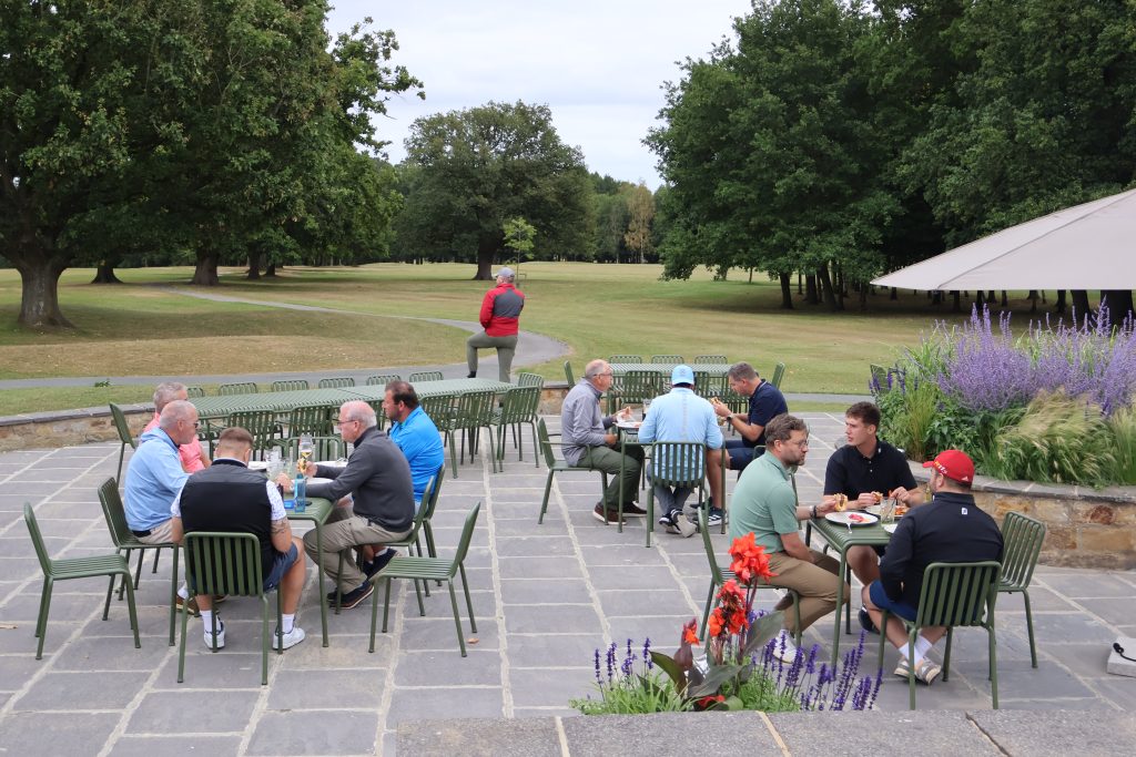 Professionals enjoying tea and networking at ICH Golf Day 2025